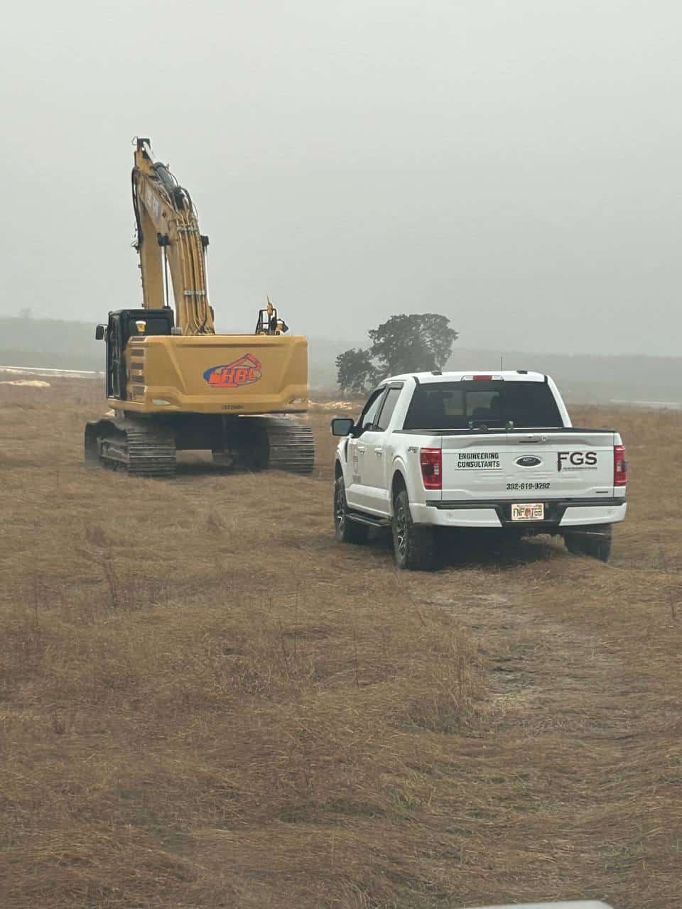 FGS field truck and excavator on a raw Florida site during a pre-construction geotechnical investigation